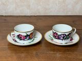 deux tasses et soucoupes posées sur une table en bois, avec un mur en arrière-plan