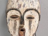 un vieux masque en bois accroché au mur