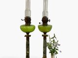 two green glass lamps sitting next to each other on a table