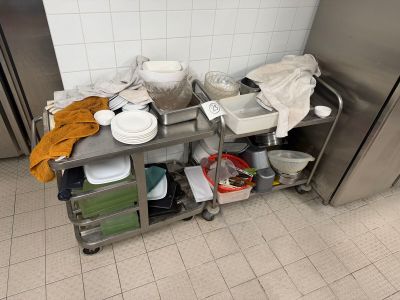 a metal cart with dishes on it in a kitchen