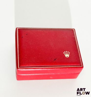 une boîte rouge ornée d'une couronne, posée sur un fond blanc