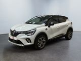 Une voiture blanche est garée dans une pièce au sol noir.
