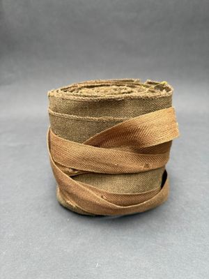 a close up of a roll of brown ribbon on a gray surface