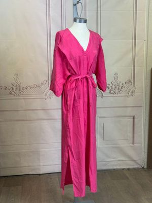 a pink dress on a mannequin stand in a room