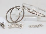 three bracelets and a pair of earrings sitting on a table