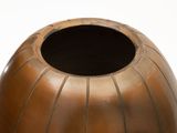a brown vase that is sitting on a white surface