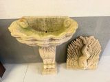 a birdbath and a statue on the floor next to each other