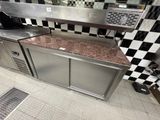 une cuisine avec des placards en inox et un plan de travail en marbre