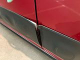 a close up of a red car with a black door handle