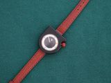 a close up of a wrist watch on a green surface