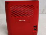 a close up of a red bose speaker on a white surface