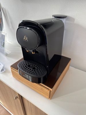 a black coffee maker sitting on a counter in a kitchen