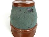 a brown and green pot sitting on a white surface