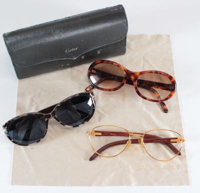 three pairs of sunglasses and a black case on a table