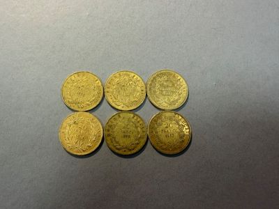 quatre pièces d'or sont disposées en ligne sur une surface grise