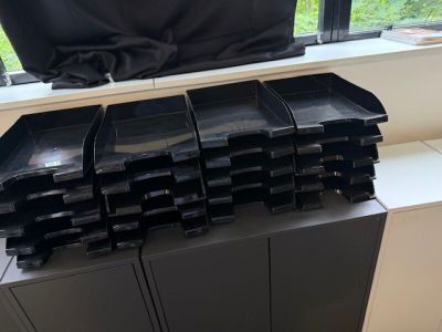 de nombreux plateaux en plastique noir empilés les uns sur les autres