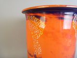 un vase orange posé sur une table