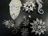 some of the brooches are sitting on a black surface