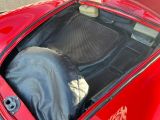 une voiture rouge avec une housse noire dans le coffre