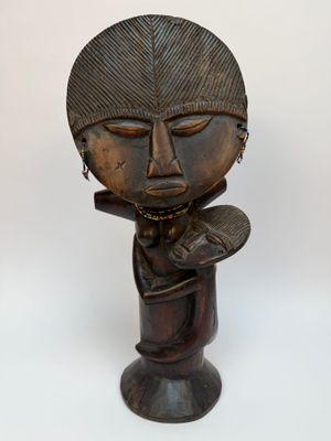 une image représentant une sculpture en bois d'une personne portant un chapeau