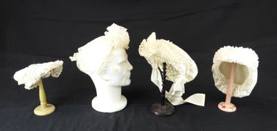 trois chapeaux et un porte-chapeaux sur fond noir