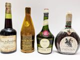 quatre bouteilles de vin sont alignées sur une surface blanche