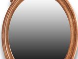 un miroir ovale orné d'un motif représentant un oiseau et une fleur