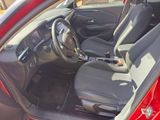 the interior of a red car with black seats and a steering wheel