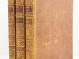 a set of three old books sitting on top of each other