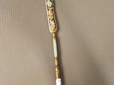 a gold pen sitting on top of a brown leather surface