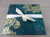 a blue and gold gift box with a white ribbon