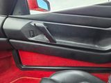 the interior of a car with red carpeting and a black door handle
