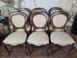 six chaises alignées sur un parquet