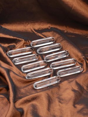six clear glass tubes sitting on top of a brown cloth