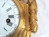 a gold clock that is sitting on a white table