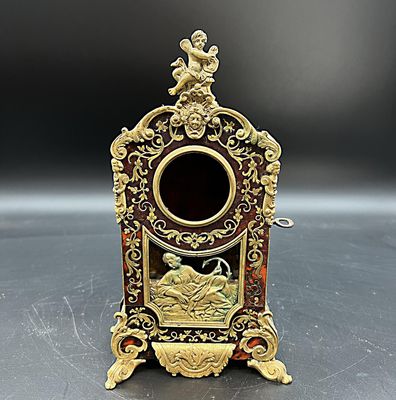 une image représentant une petite horloge ancienne posée sur une table, sur fond noir