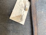 a piece of luggage sitting on the ground with a tag attached to it