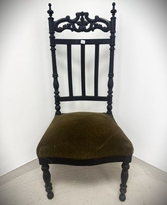 an image of a black chair with a green velvet seat
