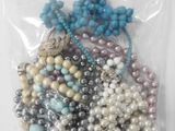 un gros plan d'un sachet de perles assorties posé sur une surface blanche