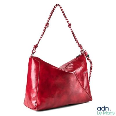 un sac à main rouge dont la poignée est ornée d'une chaîne