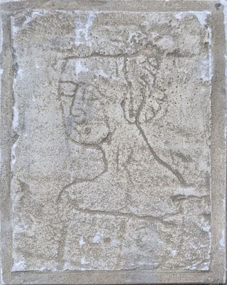 an image of a stone plaque with a woman ' s face on it