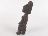 an old wooden statue of a woman sitting on a stool