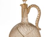 a glass bottle with a gold decoration on it