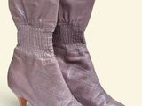un gros plan sur une paire de bottes violettes sur fond blanc