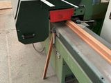 a machine that is cutting a piece of wood on a table