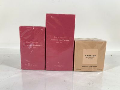 three boxes of perfume sitting next to each other on a table