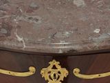 a marble top on a wooden chest of drawers