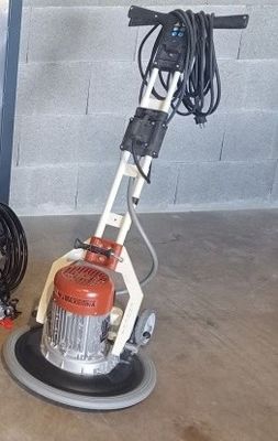 une machine posée sur le sol à côté d'un tuyau d'arrosage