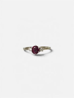 Gros plan sur une bague ornée d'une pierre rouge