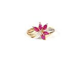 a close up of a gold ring with a pink flower on it